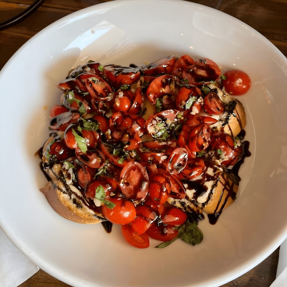 Oceanside Pizza's bruschetta appetizer, with chopped tomatoes, basil, and balsamic glaze on toasted bread.